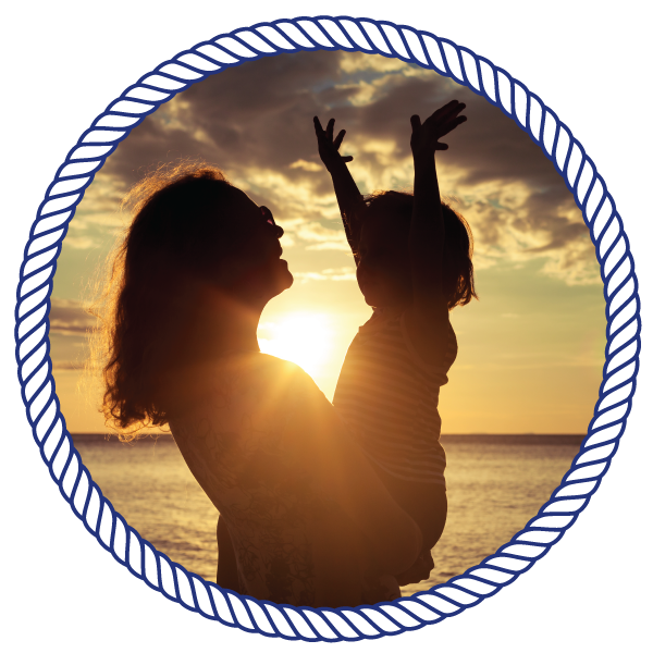 mother holding their child, looking out at a sunset