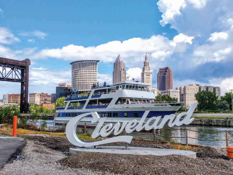 Conventions & Conferences - Feature Image a sign "cleveland" on a mount, with the goodtimeiii boat in the background