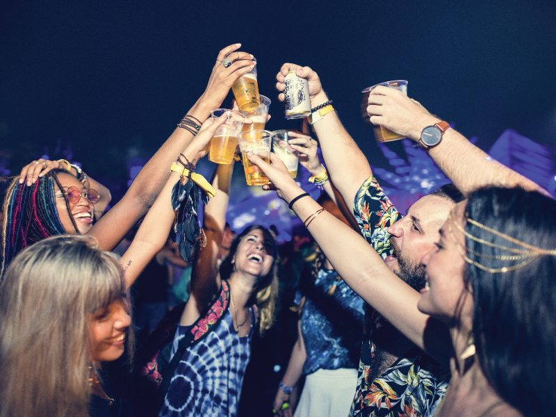 group of people cheersing with their drinks, in the middle of the night